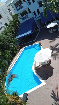 an overhead view of a swimming pool with an umbrella at Calypso Beach Hotel in Boca Chica