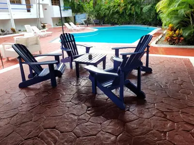 a group of chairs and a table next to a pool at Calypso Beach Hotel in Boca Chica