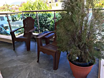 two chairs sitting on a balcony with plants at Charming 1b Apto Walk To The Beaches Main Street in Sosúa