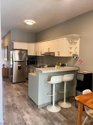 a kitchen with white cabinets and a stainless steel refrigerator at Casa Lambí in Cabrera