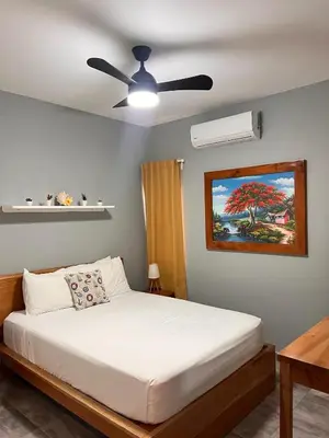 a bedroom with a bed and a ceiling fan at Casa Lambí in Cabrera