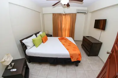 a bedroom with a bed and a ceiling fan at Acuarium Suite Resort in Santo Domingo