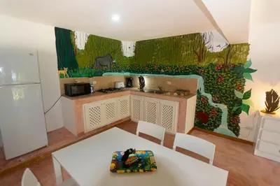 a kitchen with a white table and a painting on the wall at Studio Lotte - Ocean Front in Las Galeras
