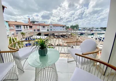 a balcony with a table and chairs and a harbor at Unique Luxury Pent House At Marina Casa De Campo in La Romana