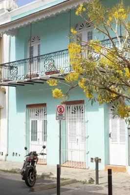 a motorcycle parked in front of a blue building at FIXIE LOFTS - Colonial Villa Suites with Pool in Santo Domingo