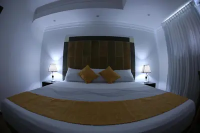 a bedroom with a large bed with two lamps at Hotel Vicentina in Boca Chica