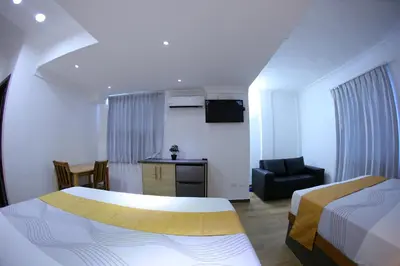 a hotel room with a bed and a chair at Hotel Vicentina in Boca Chica