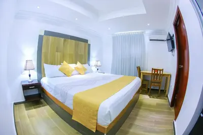 a bedroom with a bed and a table and a chair at Hotel Vicentina in Boca Chica