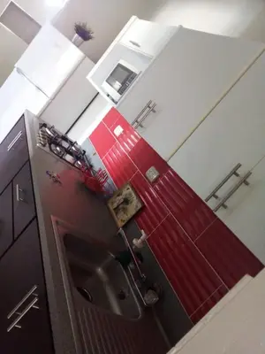 a kitchen with a red refrigerator and a sink at Apartahotel MACADANA in Nagua