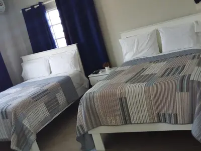 two beds sitting next to each other in a bedroom at Apartahotel MACADANA in Nagua