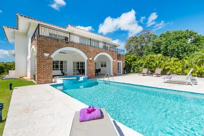 a home with a swimming pool and a house at Luxury & Modern Villa with Pool at Cocotal Golf & Country Club in Punta Cana