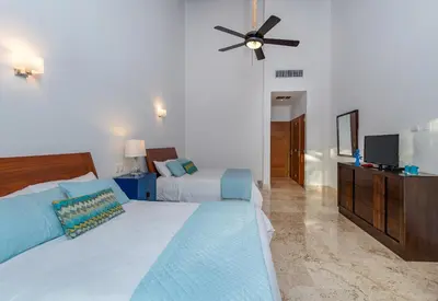 a bedroom with two beds and a ceiling fan at Unique Private Villa with Pools and Golf Cart in La Romana