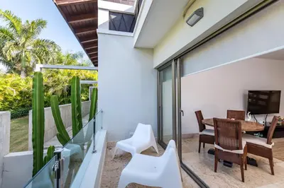 a room with a balcony with a table and chairs at Unique Private Villa with Pools and Golf Cart in La Romana