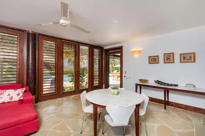 a living room with a red couch and a table at Unique Villa with Ocean and River Views - Staff & Golf Carts in La Romana