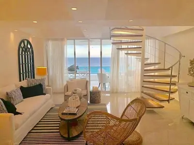 a living room with a spiral staircase and a couch at Luxury penthouse portobello in Santo Domingo