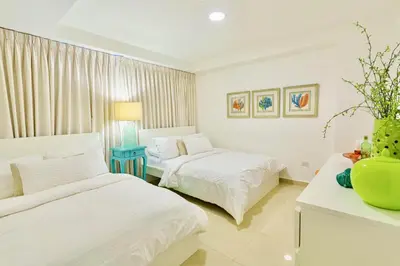 a bedroom with two beds and a table with a vase at Luxury penthouse portobello in Santo Domingo