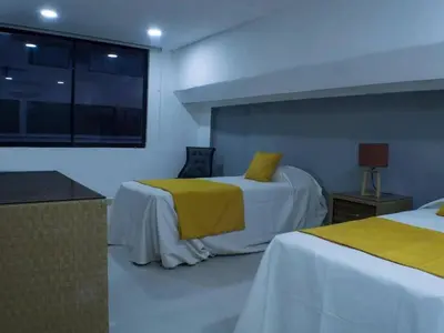 a hotel room with two beds with yellow sheets at Malecon Cozy - Premium Plus 12 in Santo Domingo