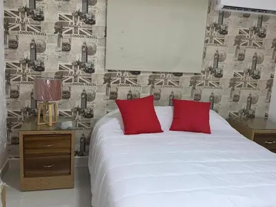 a bedroom with a white bed with red pillows at Malecon Cozy - Premium Plus 10 in Santo Domingo