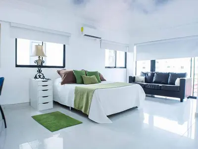 a white bedroom with a large bed and a couch at Malecon Cozy - Premium Plus 13 in Santo Domingo