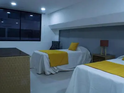 a bedroom with two beds with yellow sheets and a window at Malecon Cozy - Premium Plus 4 in Santo Domingo