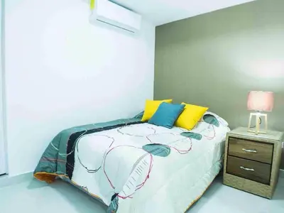 a bedroom with a bed and a night stand at Malecon Cozy - Premium Plus 4 in Santo Domingo