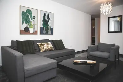 a living room with a couch and a table at Residenciales H1 & H2 - Breakfast & Room Service - Airport close in Santiago de los Caballeros