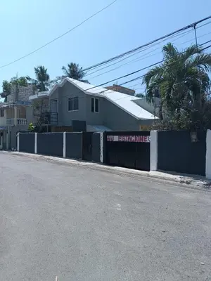 a street with a fence and a house at Caribean House in Boca Chica