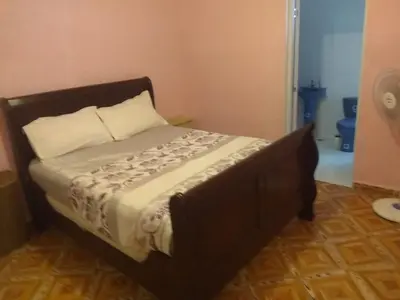 a bed in a room with a wooden frame at Caribean House in Boca Chica
