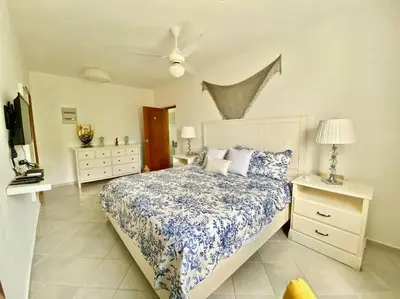 a bedroom with a bed with a blue and white comforter at Beautiful Apt Dominicus Bayahibe, Walk To Beach! in La Laguna