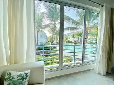 a living room with a large window with a view of the ocean at Beautiful Apt Dominicus Bayahibe, Walk To Beach! in La Laguna
