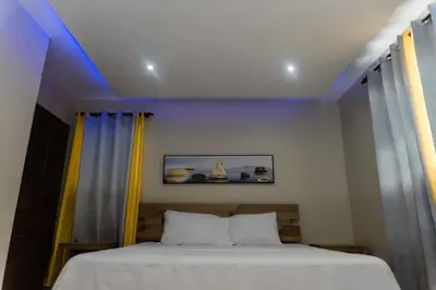 a bedroom with a bed with yellow and blue lights at Verde Bonavita in Santiago de los Caballeros
