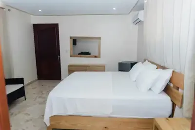 a bedroom with a white bed and a mirror at Verde Bonavita in Santiago de los Caballeros