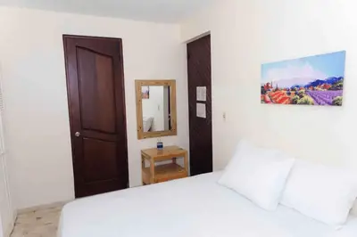 a bedroom with a white bed and a mirror at Verde Bonavita in Santiago de los Caballeros