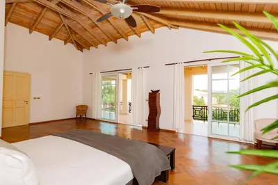 a bedroom with a bed and a ceiling fan at Exclusive Villa at Hideaway Beach in Cabarete