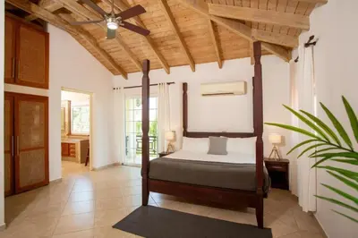 a bedroom with a bed with a wooden ceiling at Exclusive Villa at Hideaway Beach in Cabarete