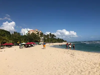 a group of people walking on a beach at La Gaviota B3 in Juan Dolio