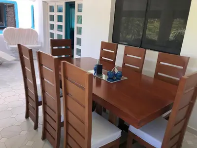 a dining room table with chairs and a wooden table at La Gaviota B3 in Juan Dolio