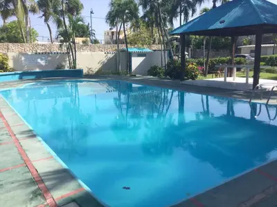 a large pool of blue water with a gazebo at La Gaviota B3 in Juan Dolio