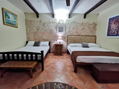 a bedroom with two beds and a table in it at Mansion Colonial Boutique Hotel Pool Jacuzzi Bar Restaurant by BTC Group Crypto in Santo Domingo
