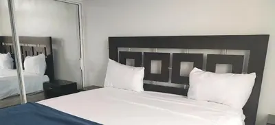 a bedroom with a large bed with white sheets and pillows at The biggest swimming pool in Sosua, frente a la piscina más grande en sosua in Sosúa