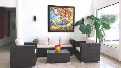 a living room with a couch and a painting on the wall at The biggest swimming pool in Sosua, frente a la piscina más grande en sosua in Sosúa