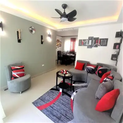 a living room with a gray couch and red pillows at Your Space piscina, parque infantil, 3 habitaciones , Res Breezes Santiago in Santiago de los Caballeros