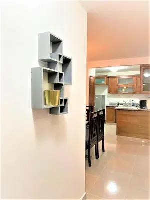 a kitchen and dining room with a wall with shelves at Your Space piscina, parque infantil, 3 habitaciones , Res Breezes Santiago in Santiago de los Caballeros