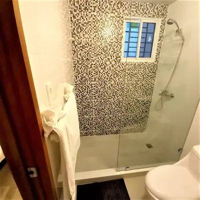 a bathroom with a shower and a toilet at Your Space piscina, parque infantil, 3 habitaciones , Res Breezes Santiago in Santiago de los Caballeros
