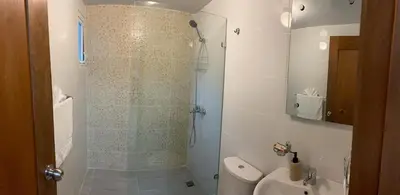 a bathroom with a shower with a toilet and a sink at Your Space piscina, parque infantil, 3 habitaciones , Res Breezes Santiago in Santiago de los Caballeros