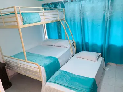 two bunk beds in a room with blue curtains at La Gaviota B1 in Juan Dolio