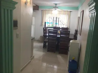 a room with a desk and a kitchen with a window at La Gaviota B1 in Juan Dolio