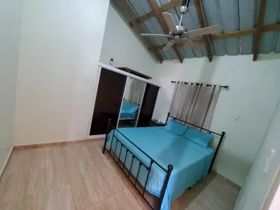 a bedroom with a blue bed and a ceiling fan at Oasis de Paz 3 in Jarabacoa