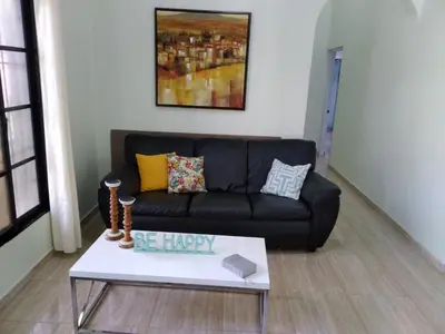 a living room with a black couch and a coffee table at Oasis de Paz 3 in Jarabacoa
