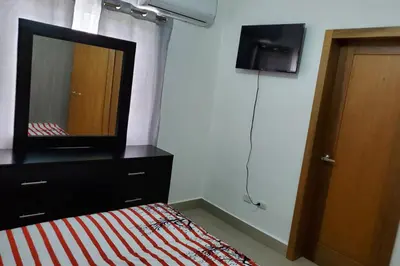 a bedroom with a bed with a mirror and a dresser at Hanly Roger's Brand new place in San Felipe de Puerto Plata